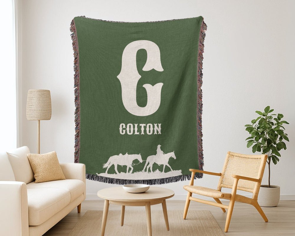 Green blanket with 'Colton' and horse design in a living room setting